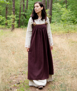 Wool apron dress with pleats from Kostrup, decorated with a woven trim